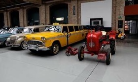 A Checker Aerobus stands next to a Porsche tractor in the Meilenwerk Berlin. (Photo by Ronan McGrath.)