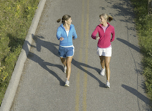 Exercise With Friends // Two women walking in a park (©photolibrary.com/Monalyn Gracia)
